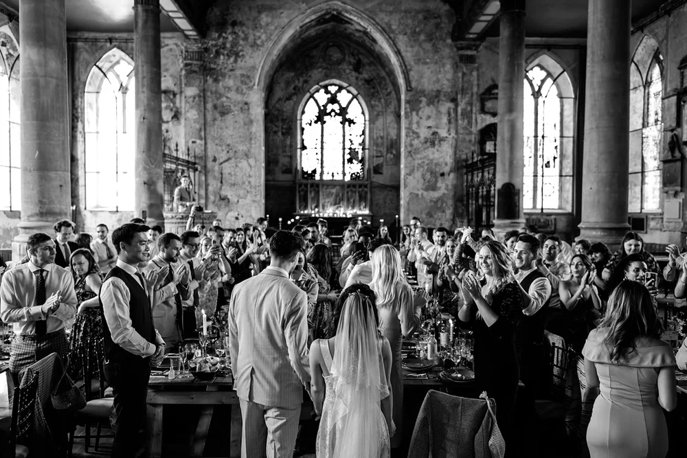 A packed church reception with the couple in the middle of the crowd