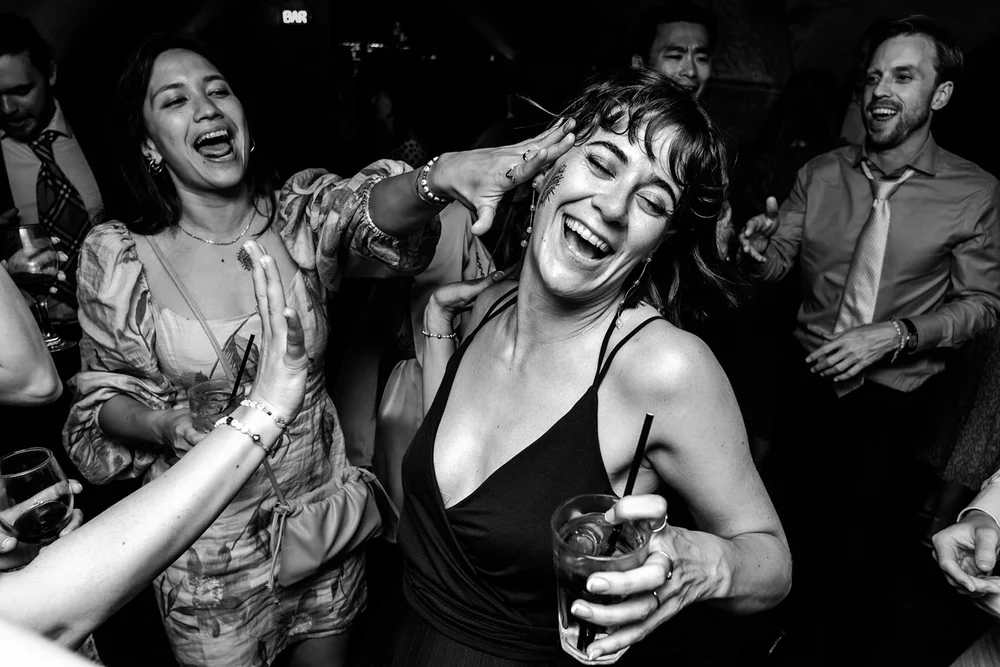 Guests dancing and laughing with drinks in hand