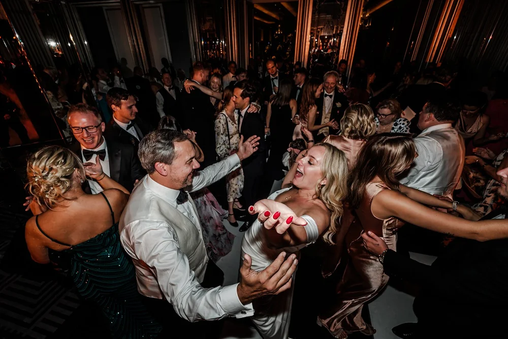 A packed dance floor in an ornate gilded room