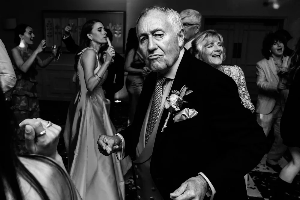 Bride dancing with her father surrounded by guests