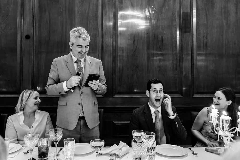 A speech read from a phone as the couple laugh at the table