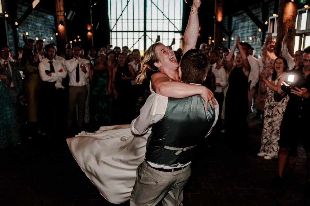 A guest swinging their partner around the dance floor as the crowd cheers