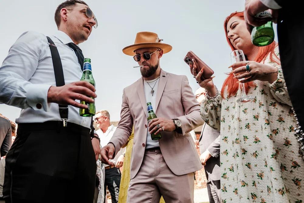 Guests drinking bottled beer together outside in the sunshine