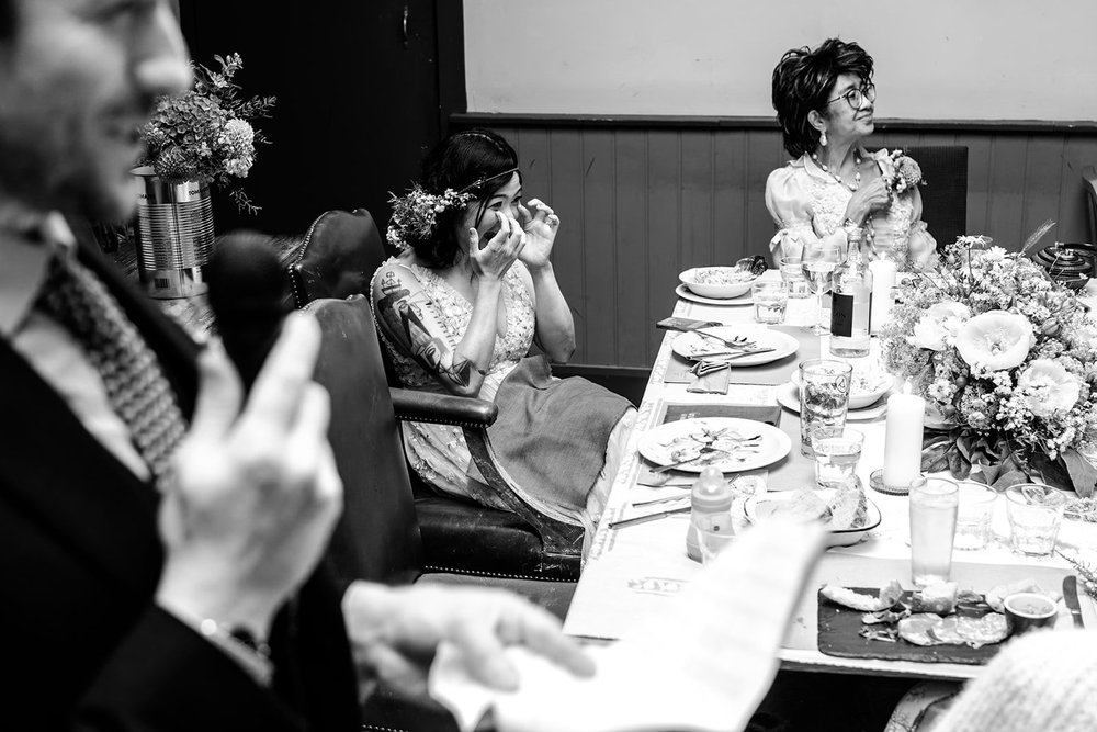 Guests wiping their eyes during an emotional speech at the wedding breakfast