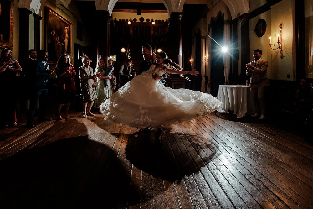 Bride spinning her dress out across the floor of a candlelit room
