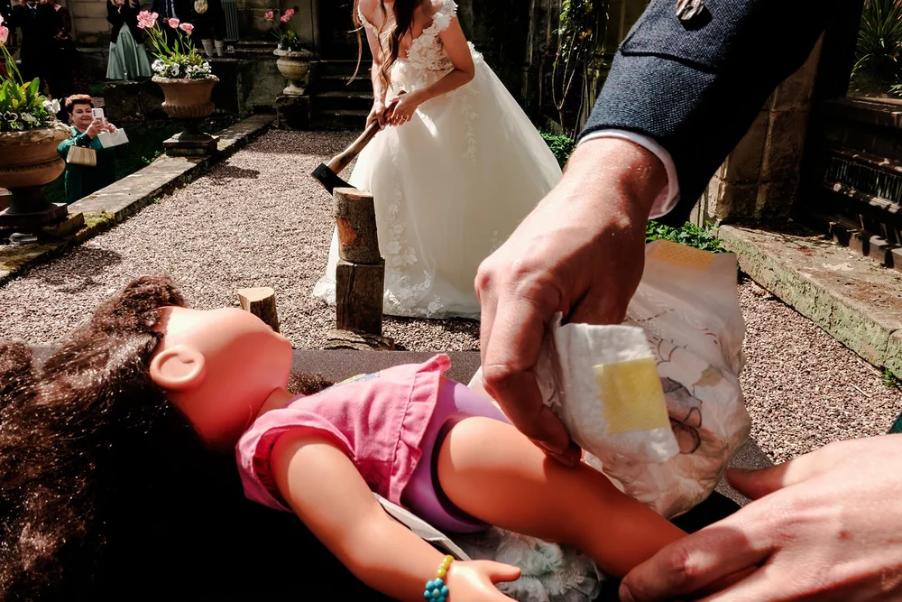 A child guest lying on the ground being handed a drink