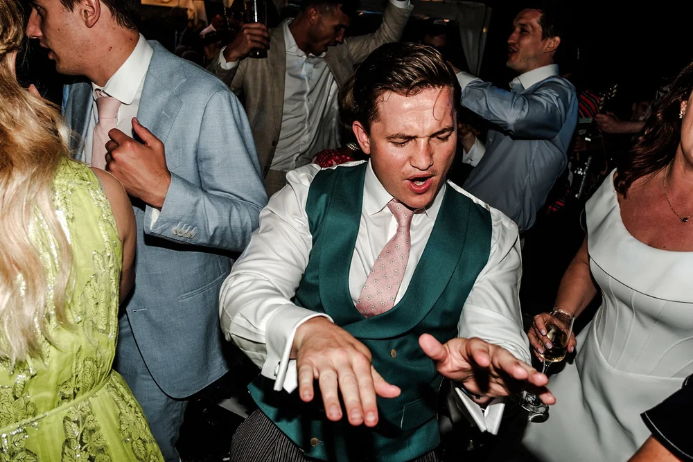 Groom dancing with guests crowded around him