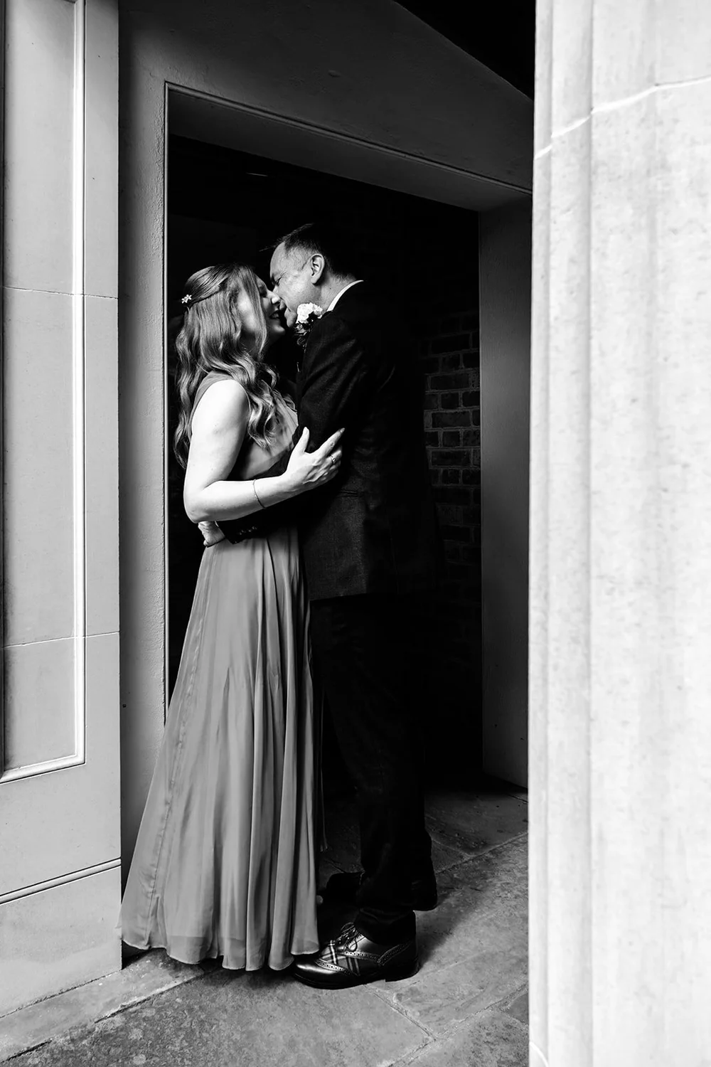 Bride and groom embracing in a narrow doorway