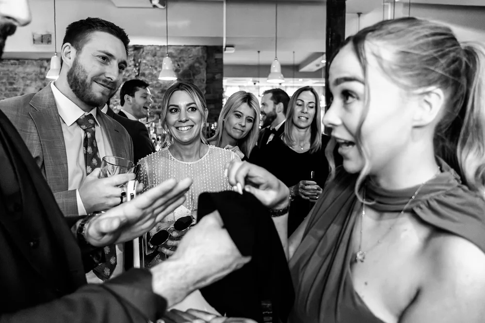 Guests laughing together over drinks at the reception