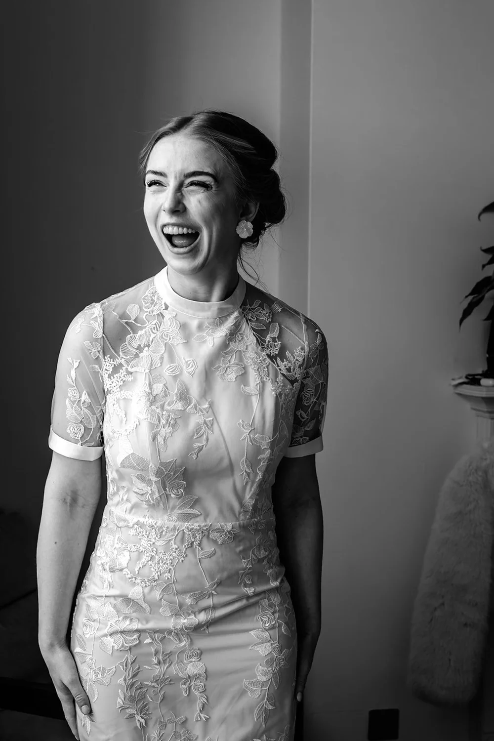 Bride laughing with delight once her dress is finally on