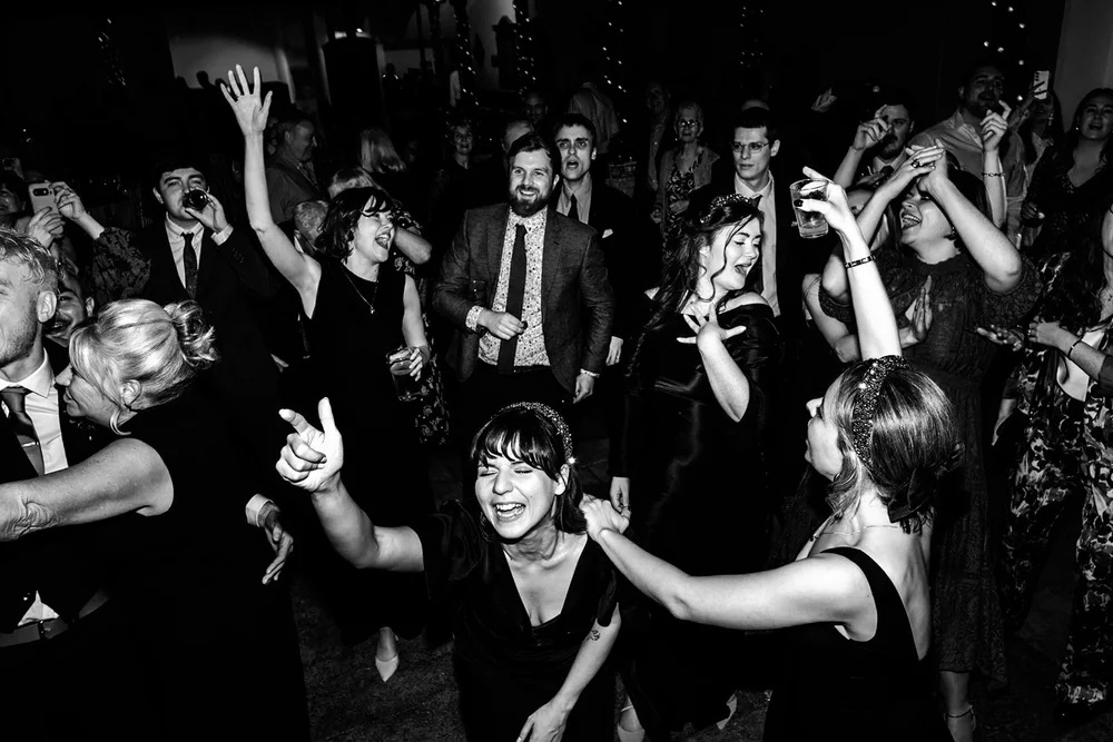 A packed dance floor of guests with their arms in the air