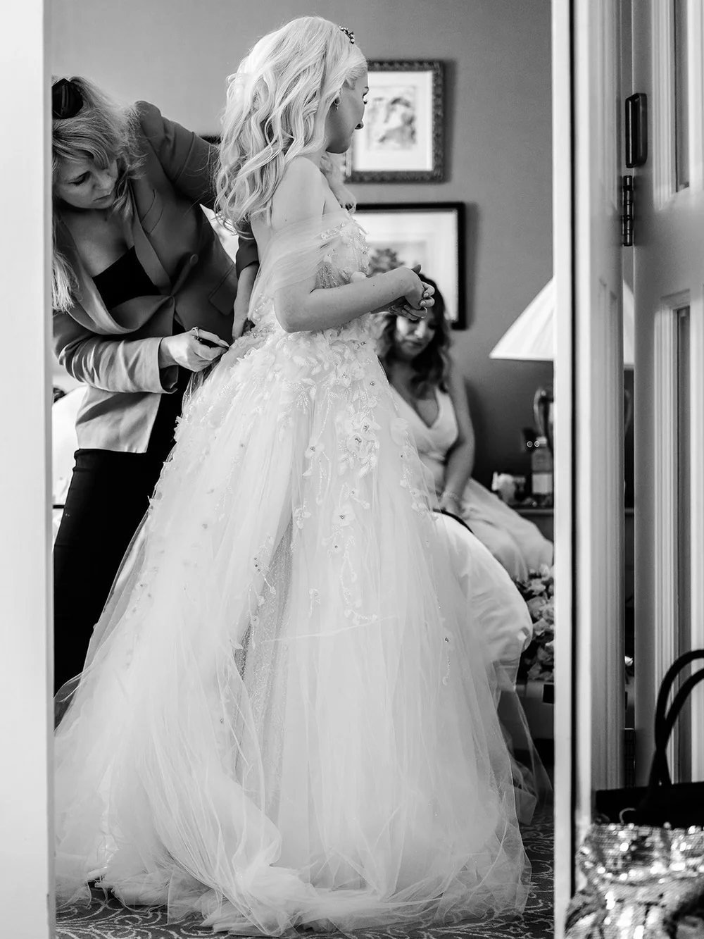Bride being helped into her dress on the wedding morning