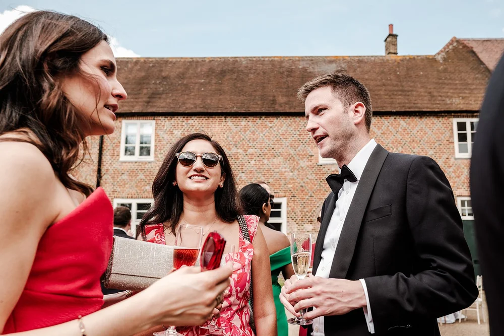 Guests chatting over drinks in the courtyard after the ceremony