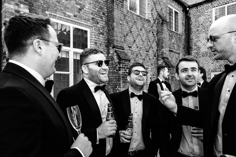Groomsmen laughing together during the drinks reception