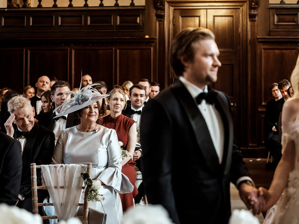 Groom waiting at the front of the room as the bride arrives