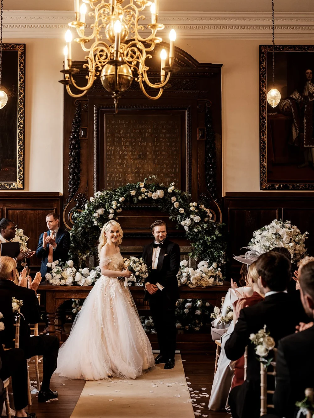 Bride and groom beneath the flower arch during the ceremony