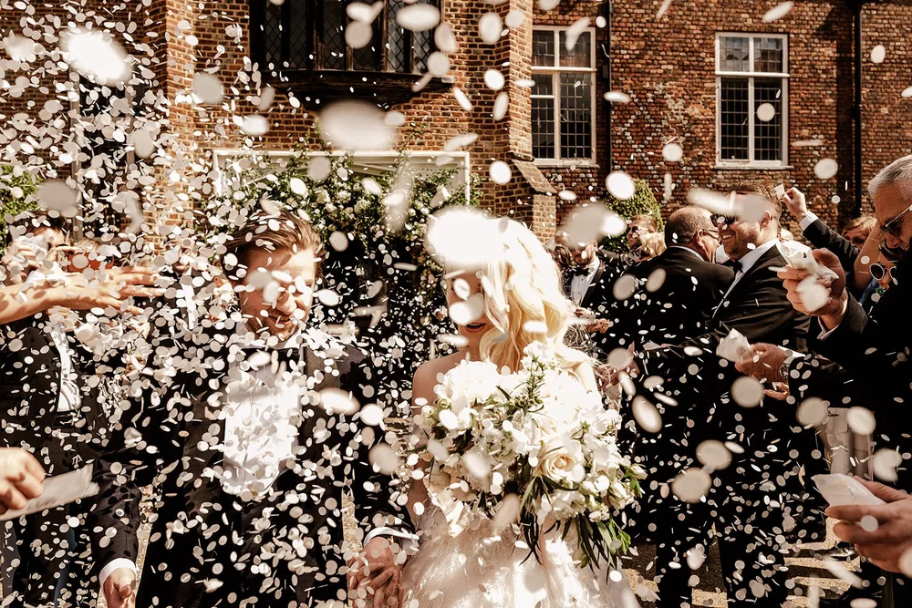 Bride in the middle of a confetti shower outside