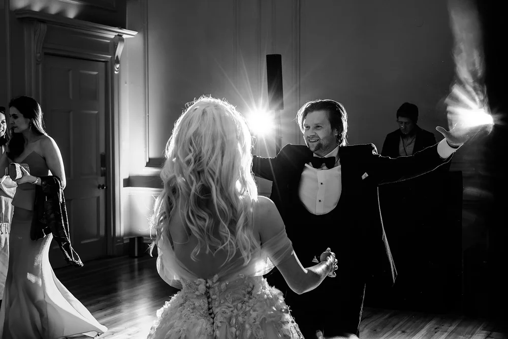 Bride and groom lit from behind on the dance floor