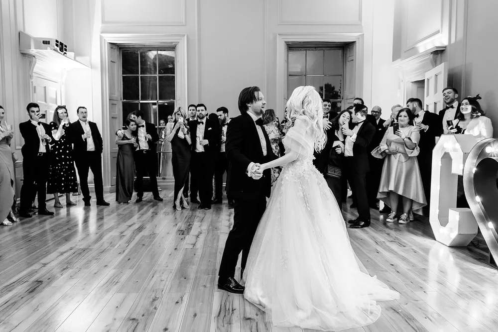 Bride and groom sharing their first dance in front of their guests