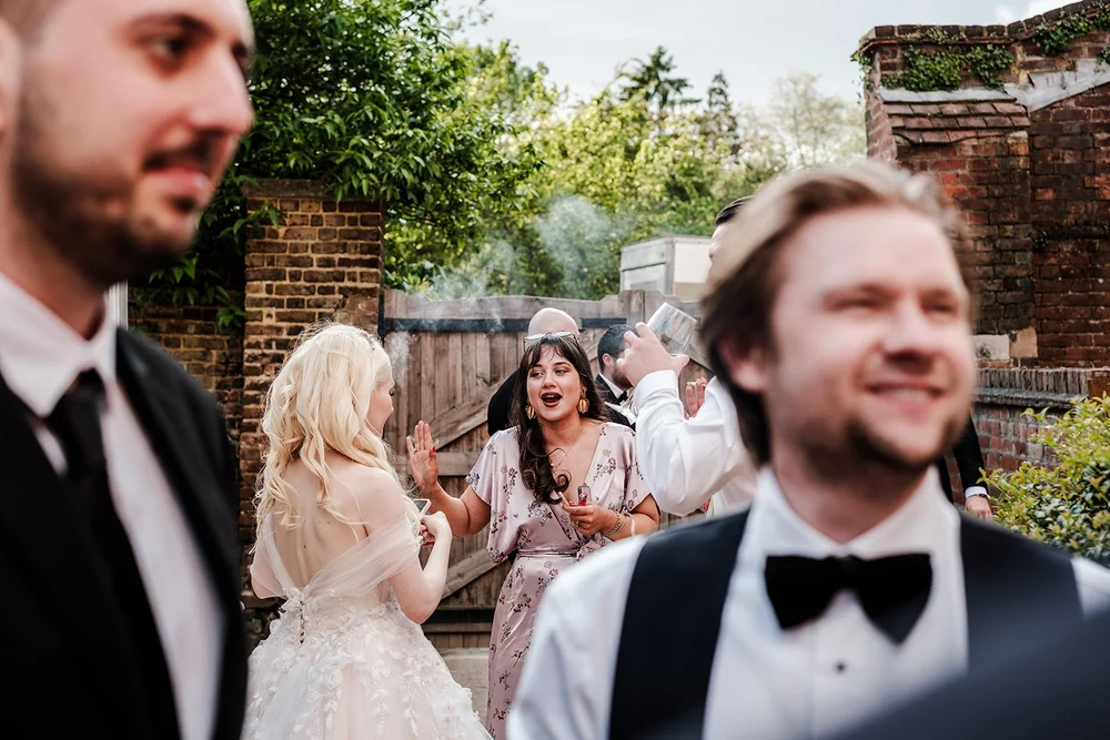 Guests laughing outside in the sunshine during the reception