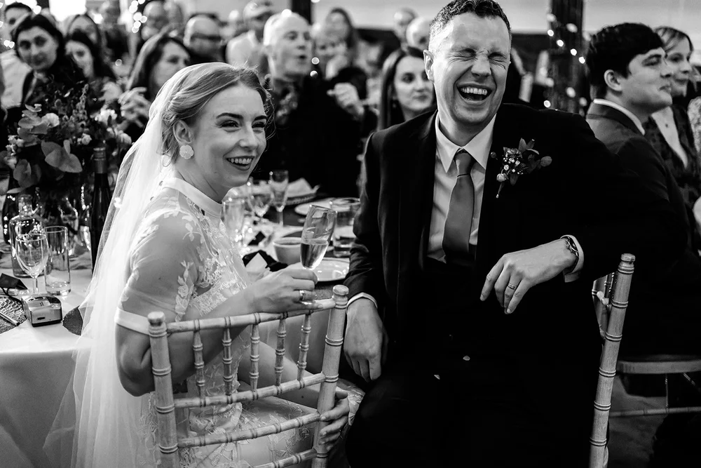 Grace and Jordan laughing during the wedding speeches at Fabrica