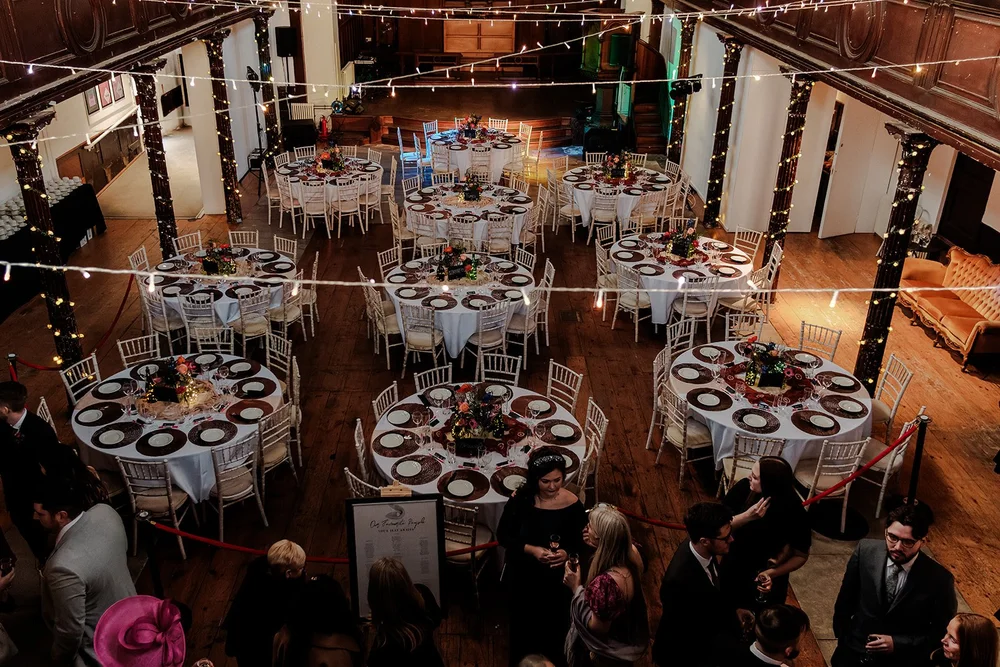 Round tables and fairy lights set for a wedding inside Fabrica Brighton