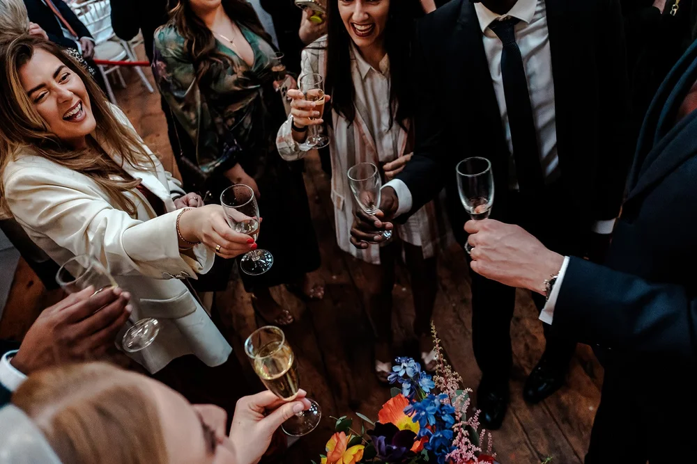 Champagne poured beside jewel toned florals at Fabrica Brighton
