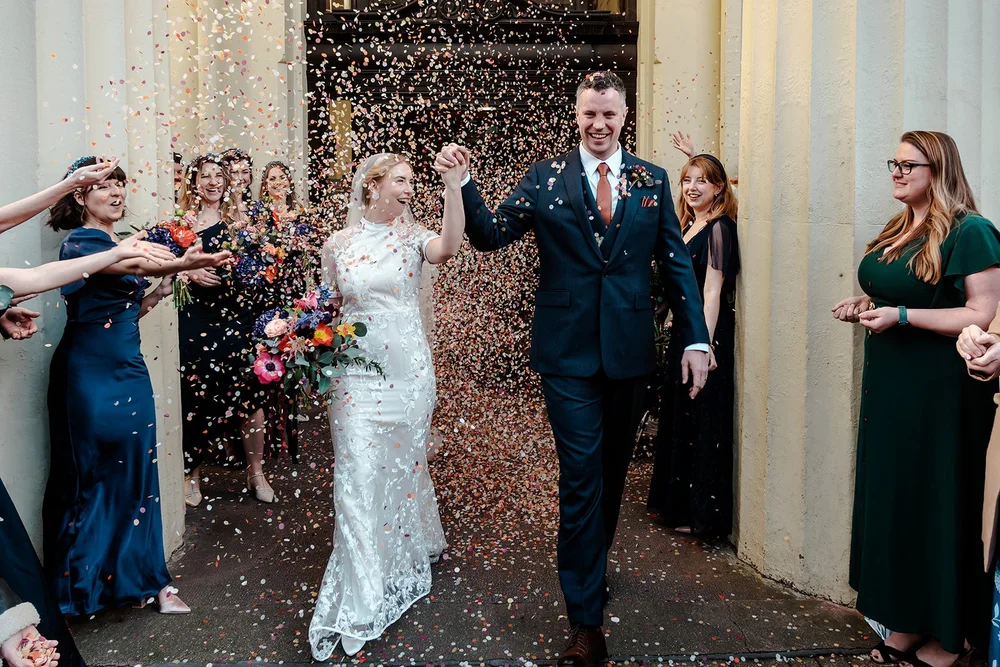 Confetti thrown over Grace and Jordan in the doorway of Brighton Town Hall