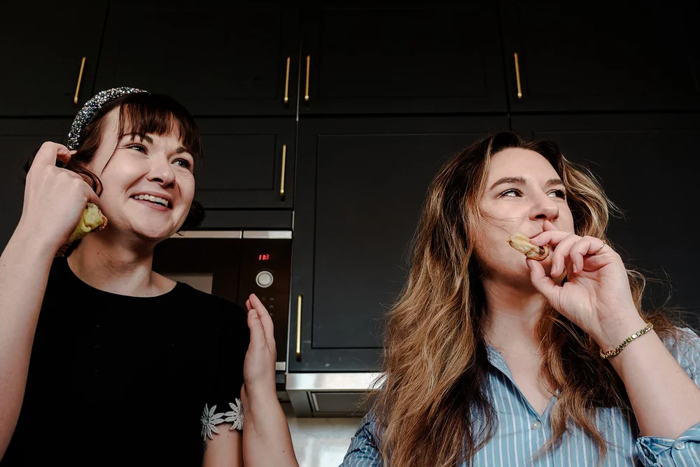 Bridesmaids laughing while putting on earrings on the wedding morning