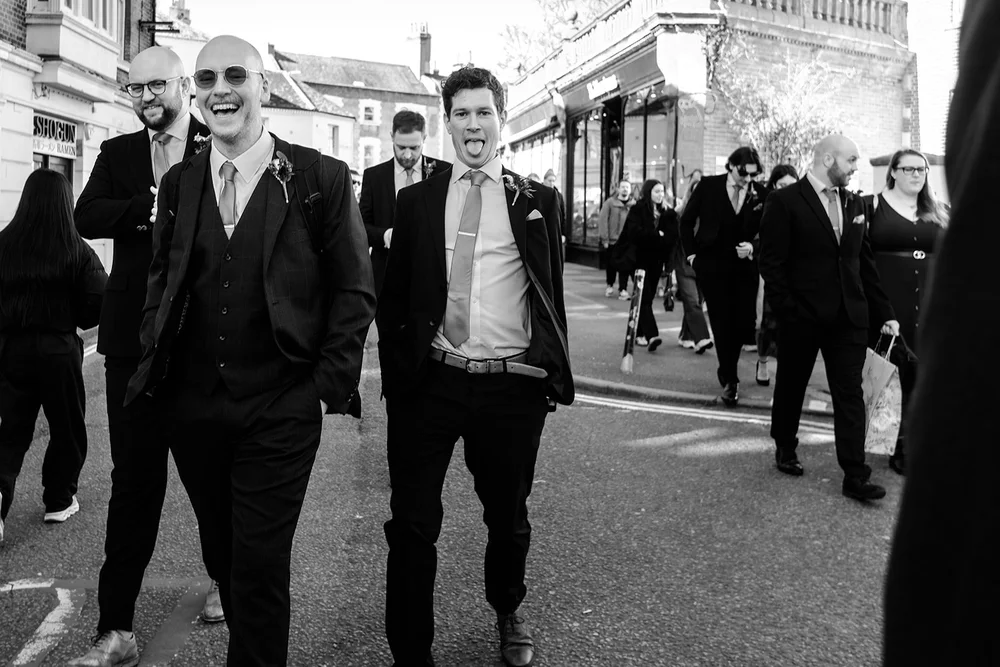 The groomsmen walking through Brighton to the Town Hall