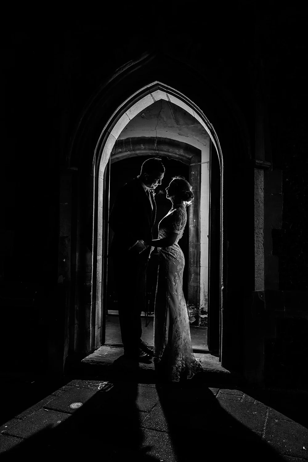 Grace and Jordan silhouetted in the Gothic arched doorway of Fabrica in Brighton