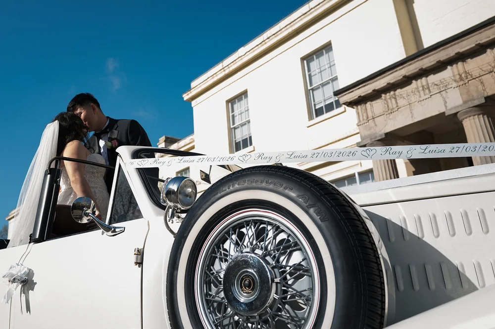 Luisa and Ray leaving the church in a vintage wedding car