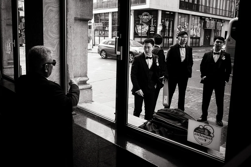 The groomsmen reflected in a shop window on the way to St Anne&rsquo;s Church