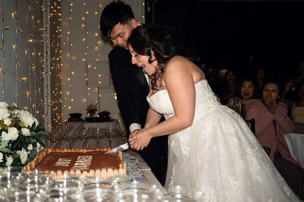 Luisa and Ray cutting their wedding cake by candlelight