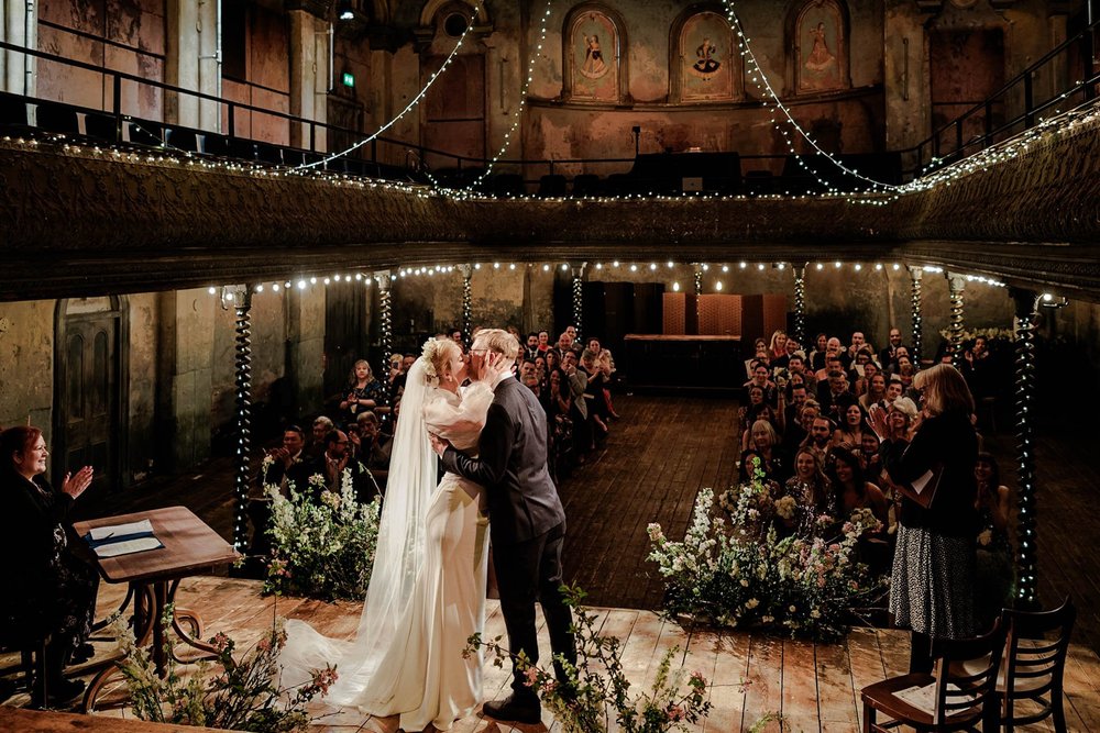 Bride walking through a grand venue hallway in beautiful natural light &mdash; elegant wedding photography