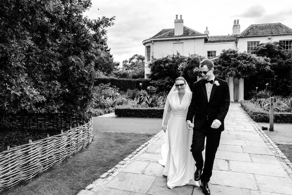Couple sharing a relaxed moment during their wedding at Pembroke Lodge Richmond Park London &mdash; natural documentary photography by Oliver Holder