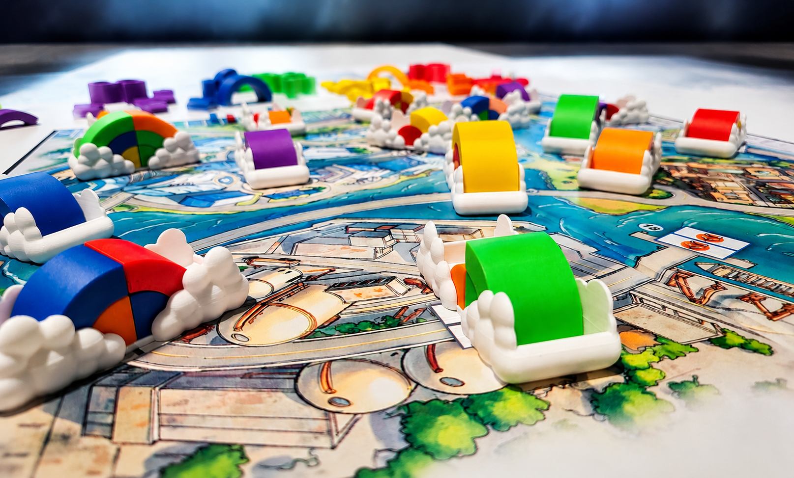 Colorful game pieces from Rainbow Blvd. on a game board, including rainbow-shaped and roller coaster-shaped tokens, on a detailed illustrated game board.
