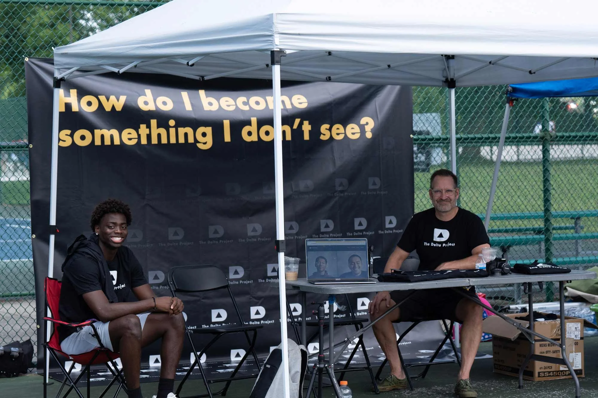 delta-project-juvenile-justice-volunteers-shurman-and-joel-sitting-at-booth.jpg