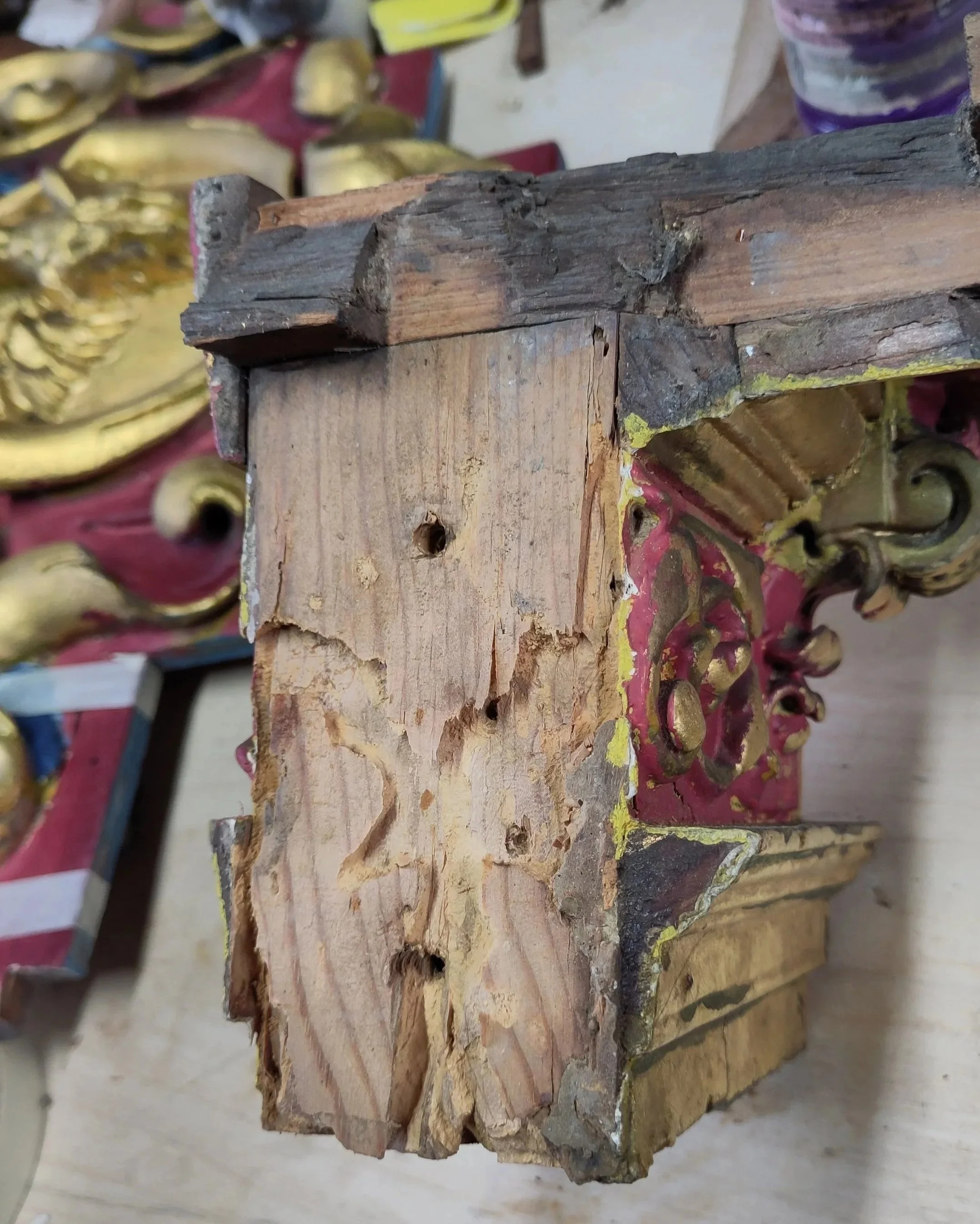 Close‑up of a carved polychrome and gilded architectural feature showing minor death‑watch beetle damage during restoration - St Mary’s Church Horden, County Durham