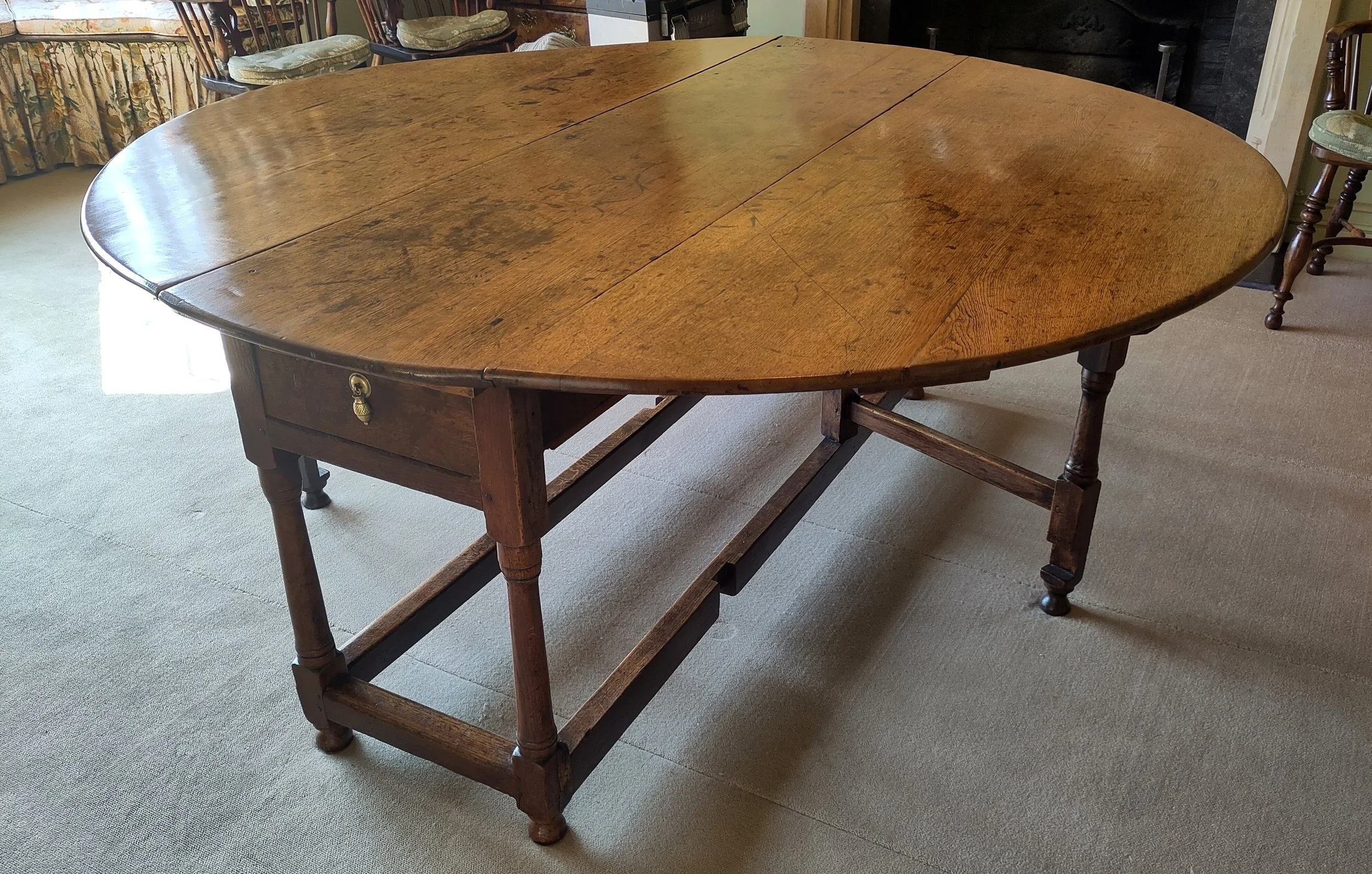 Oak gateleg dining table c.1750 was showing a dull, worn top with areas of bare wood, restored by removing the wax, sealing the surface with shellac, and rebuilding the period wax finish with a traditional beeswax and carnauba wax formula.
