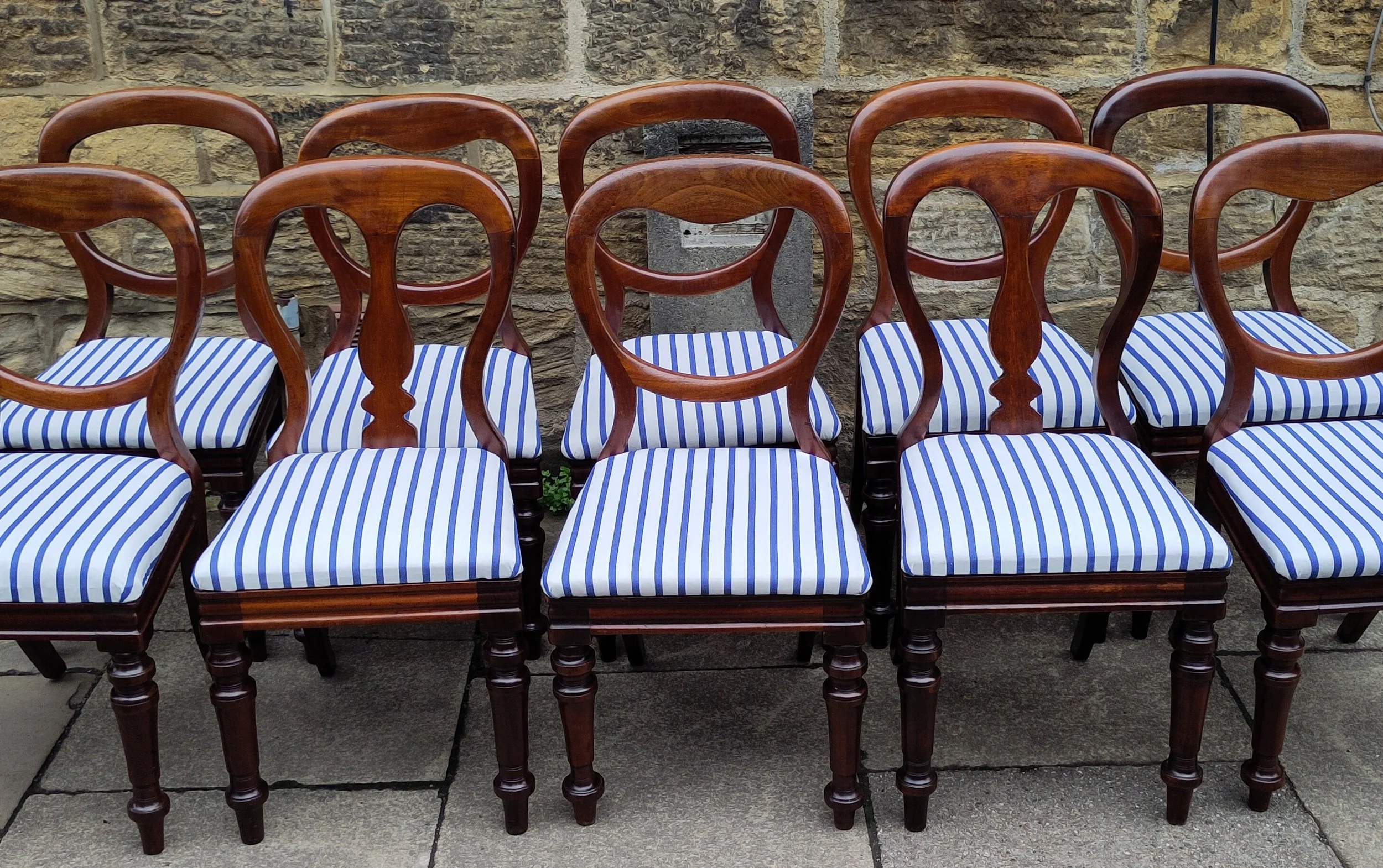 A restored set of harlequin mahogany chairs, their loose joints made good and the seats traditionally reupholstered using period‑appropriate materials