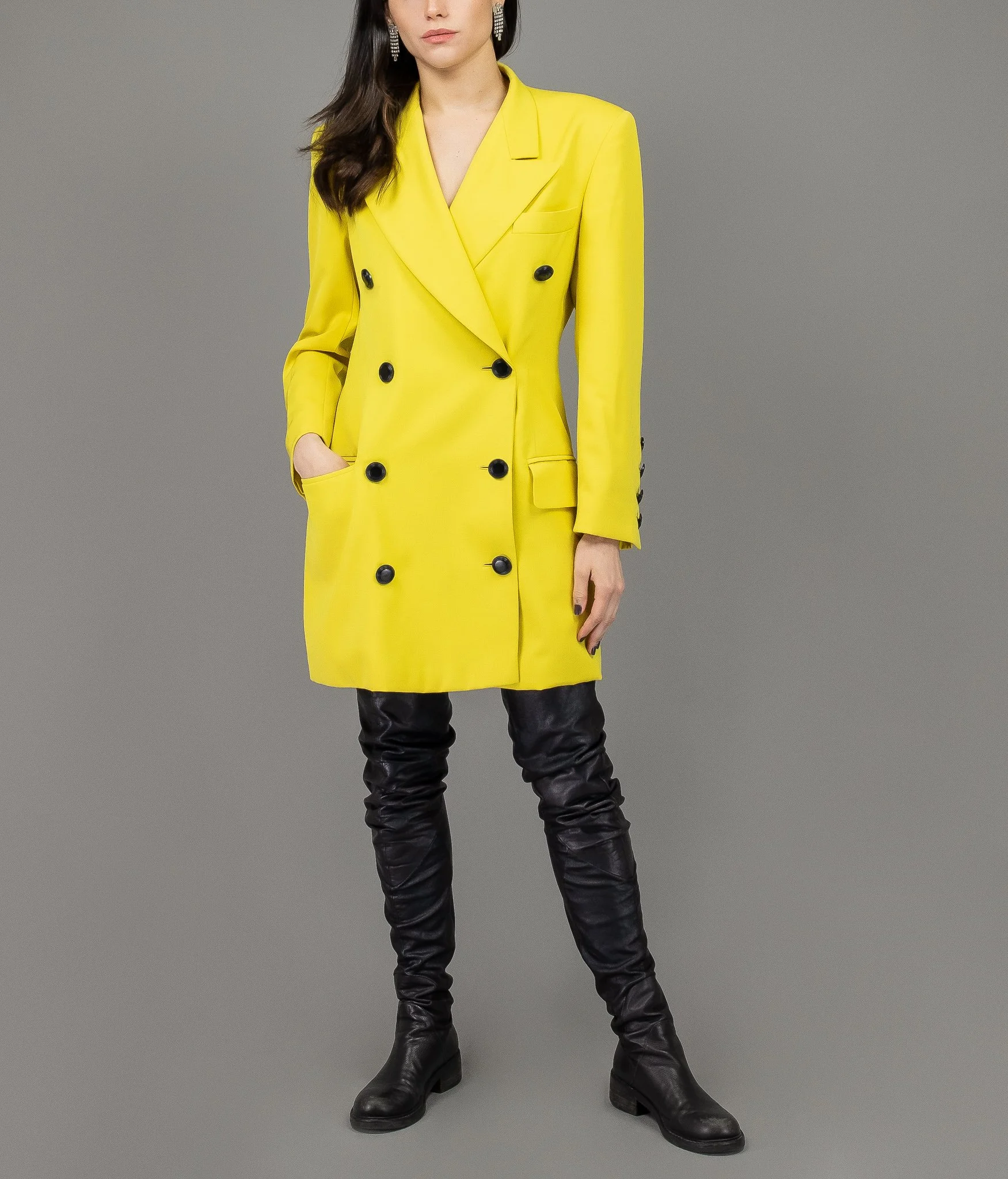 collector of vision model is wearing a medium yellow vintage Escada blazer dress with black buttons, notched collar, and padded shoulders, styled with black boots
