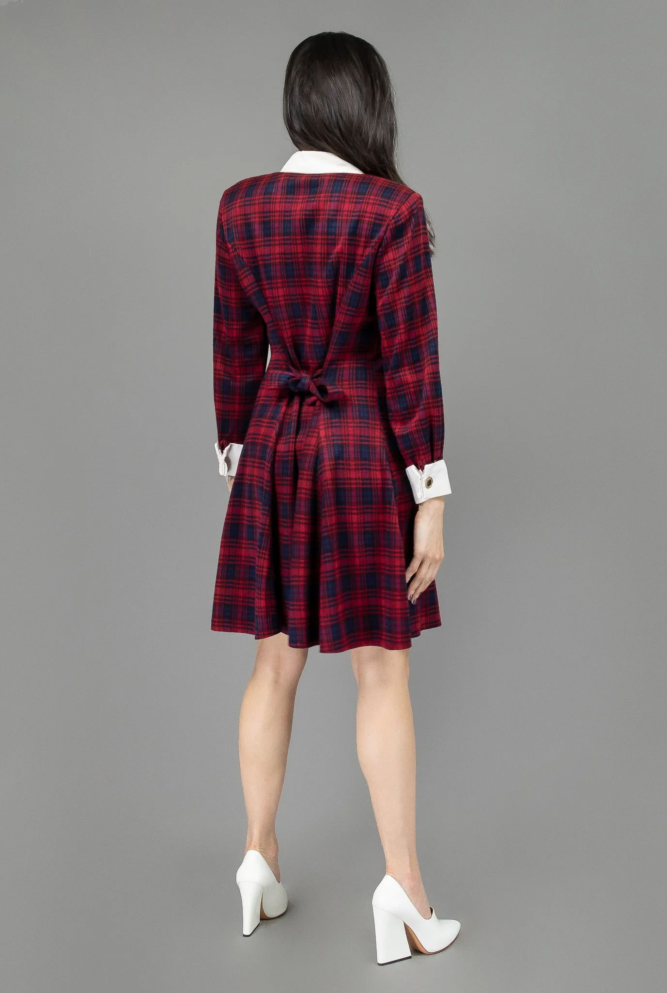 collector of vision model wearing a size medium red plaid dress showing off the back side, with white collar and cuffs, padded shoulders, button down closure and cuff buttons, adjustable back tie