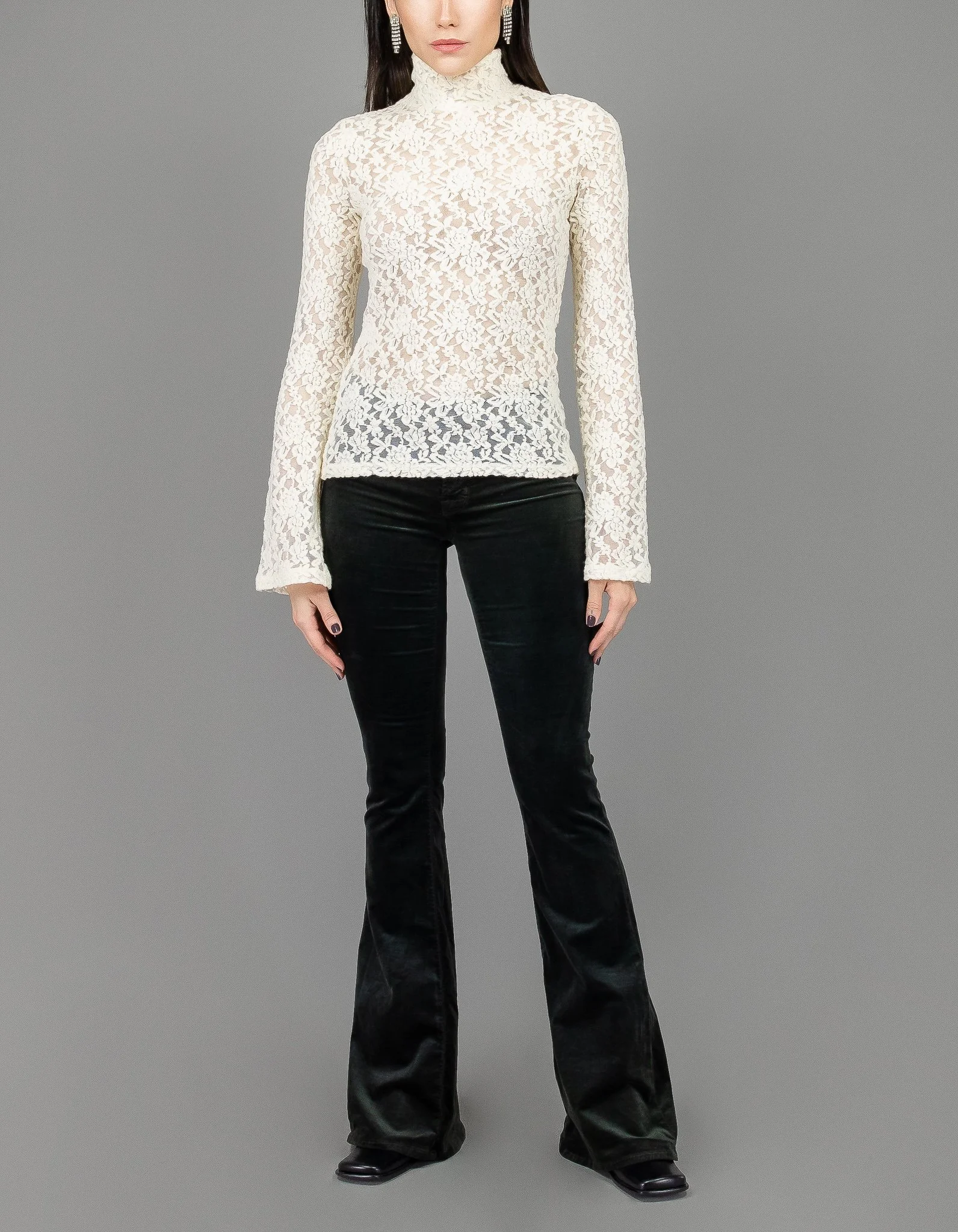 collector of vision model is wearing a size small white lace turtleneck with long bell sleeves, floral mesh lace, styled with black velvet bell bottoms