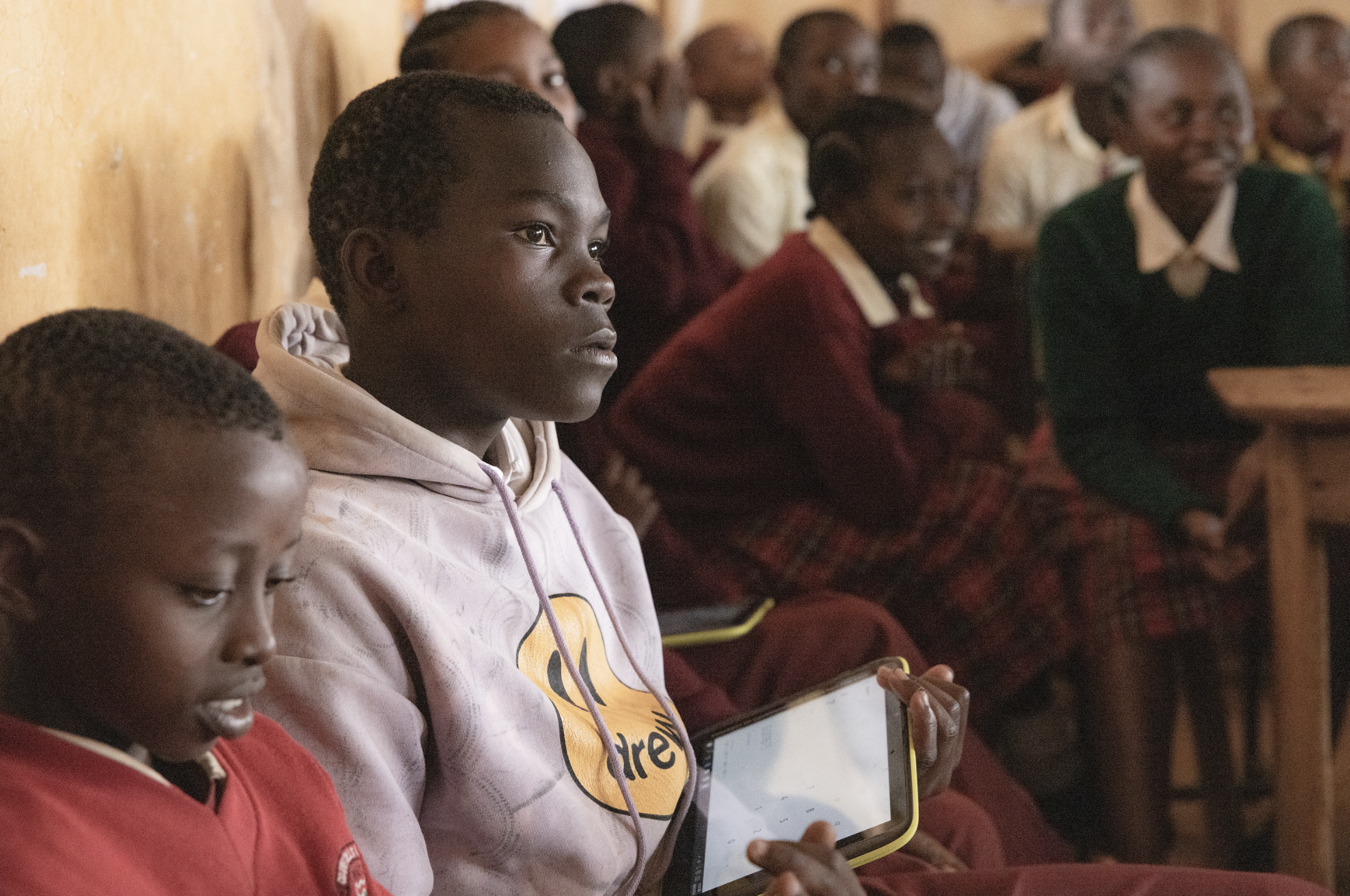 image of a group of students in a classroom in Kenya listening to a presentation