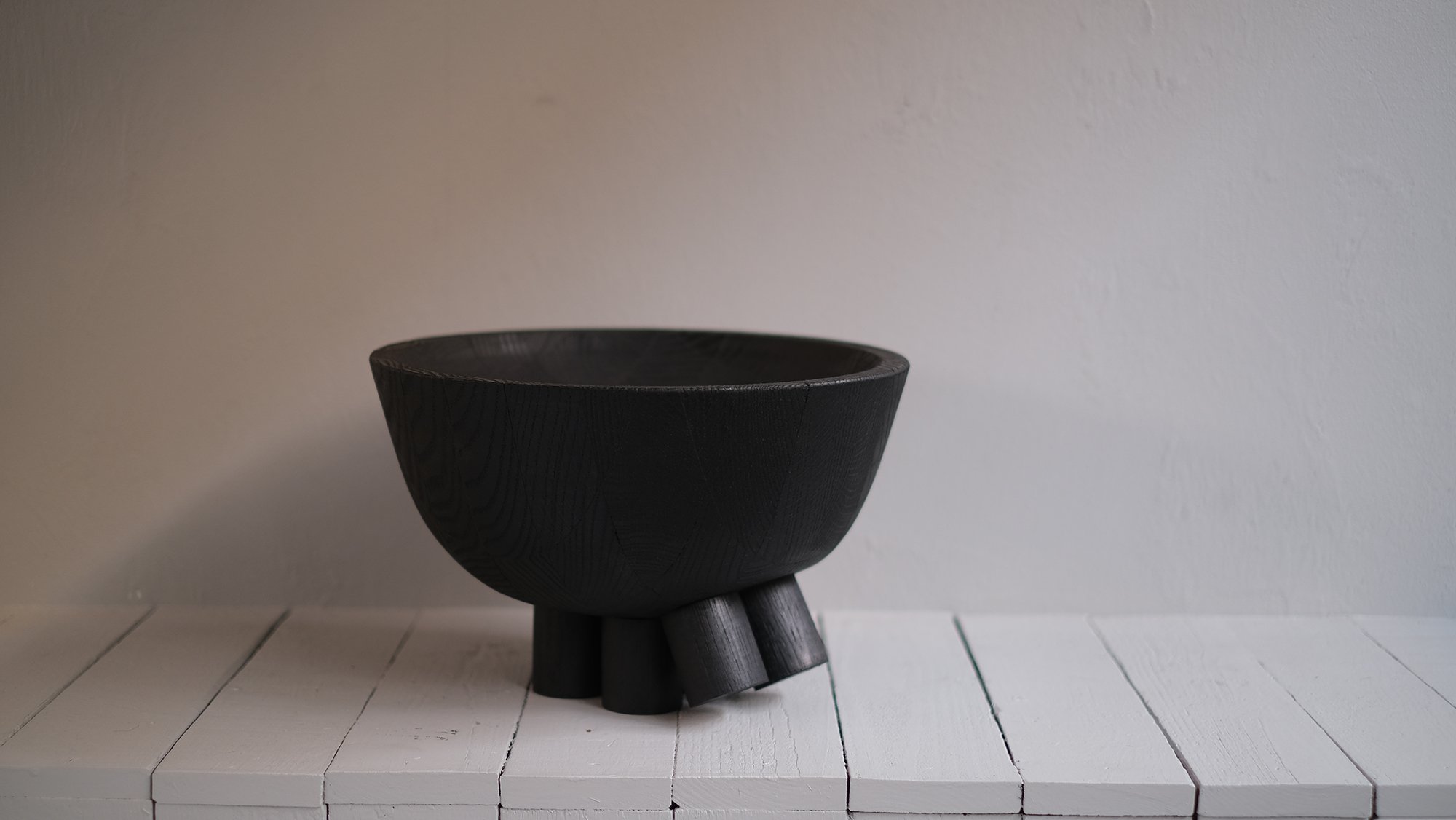 Closer view of the burned oak bowl and sculptural feet of the Walking Bowl by Arno Declercq.