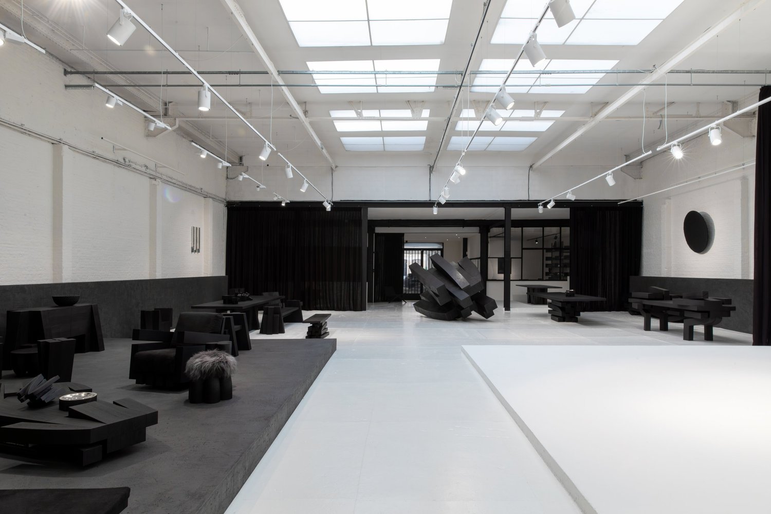Le showroom d’Arno Declercq à Anvers, avec des bancs, des tables et une sculpture en bois brûlé