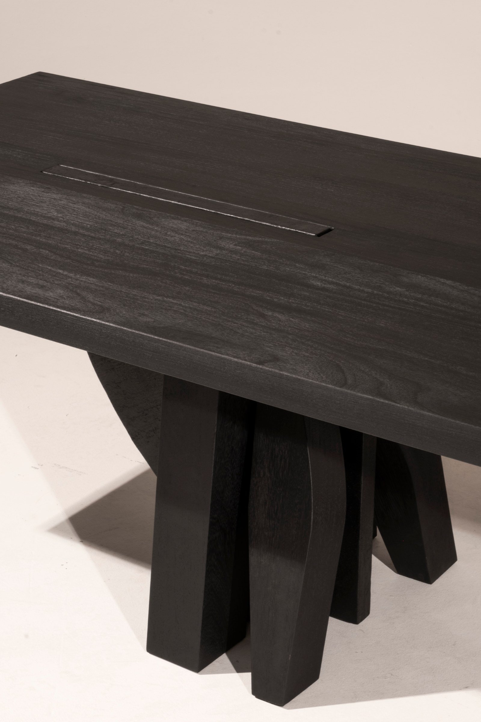 Detail of the burned Iroko grain and sculptural support of the Umbo Dining Table by Arno Declercq.