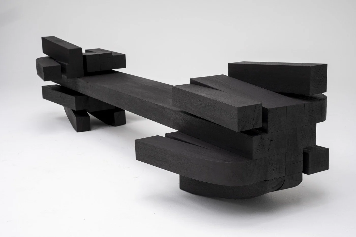 Zoumey Bench 012024 by Arno Declercq, a brutalist bench in burnt and oiled Iroko
