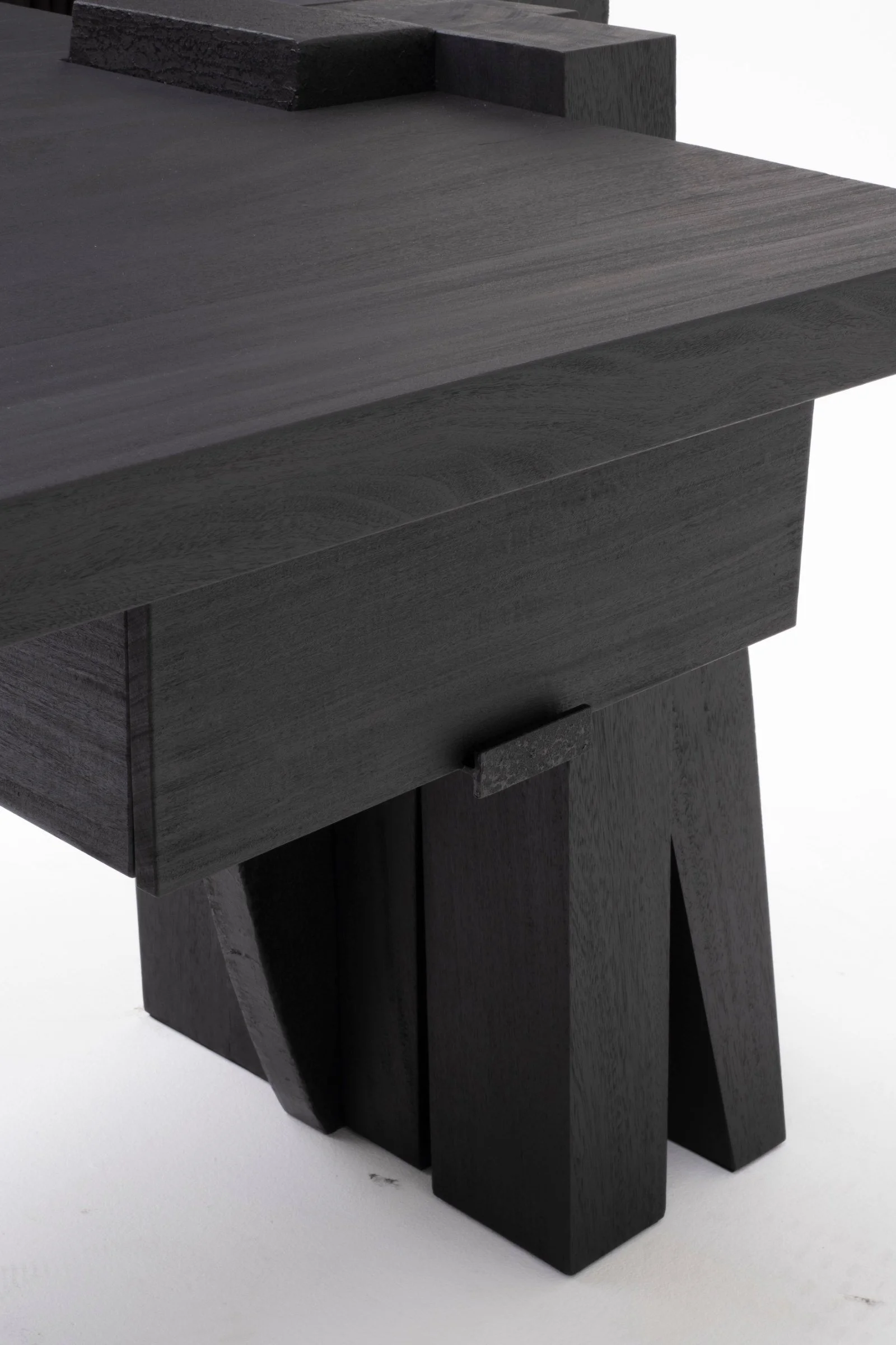 Detail of the burned Iroko top and sculptural support of the Umbo Desk by Arno Declercq.
